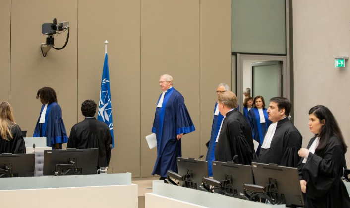 Officials and legal representatives in an international courtroom